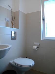 a white bathroom with a toilet and a sink at Guesthouse Bor Plitvice Lakes in Plitvička Jezera