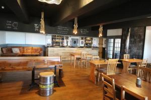 um restaurante com mesas e cadeiras de madeira e um bar em Ocean View Bar & Rooms em Laide