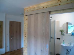 a bathroom with a wooden door and a sink at Guesthouse Bor Plitvice Lakes in Plitvička Jezera
