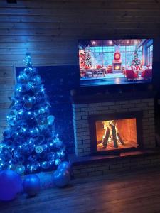 a christmas tree in a living room with a fireplace at Panorama BatumGora in Batumi