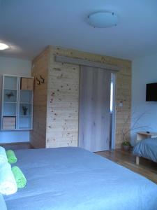 a bedroom with a blue bed with a wooden wall at Guesthouse Bor Plitvice Lakes in Plitvička Jezera
