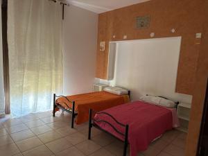 een kleine kamer met 2 bedden en een raam bij Olbia via modena in Olbia