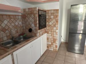 a kitchen with a sink and a refrigerator at Olbia via modena in Olbia