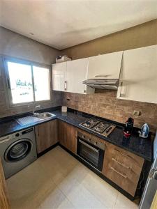 een keuken met een wastafel en een fornuis top oven bij Cosy Apartment 2 Bedrooms Golf City in Marrakesh