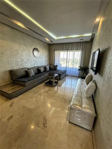 een woonkamer met een bank en een tafel bij Cosy Apartment 2 Bedrooms Golf City in Marrakesh