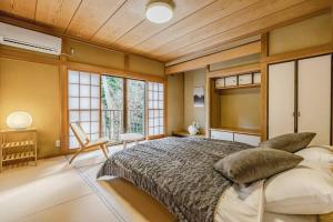 um quarto com uma cama grande e janelas em MUSUBU HAKONE KOWAKUDANI em Hakone
