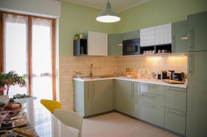 una cocina con armarios verdes y fregadero en Monferrato Bed&Bike en Murisengo