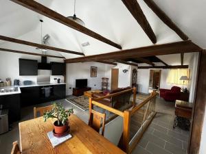 a living room with a dining table and a kitchen at The Fish Loft in Tewkesbury