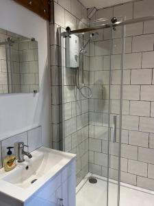 a bathroom with a sink and a glass shower at The Fish Loft in Tewkesbury