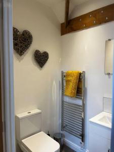 a bathroom with a toilet and two hearts on the wall at The Fish Loft in Tewkesbury