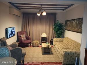 sala de estar con sofá y 2 sillas en Lovely & Calm Rooftop in Maadi 5 min from the Nile, en El Cairo