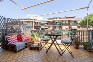 a patio with a couch and a table on a balcony at Casa del Sole - Free Parking in Rome
