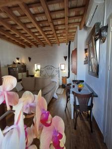 sala de estar con sofá y mesa con flores en La Guarida de Vejer Casa Rural en Vejer de la Frontera