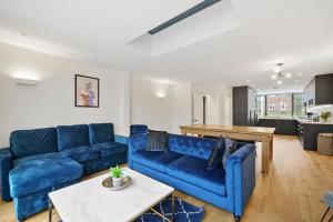 West Dulwich的住宿－Luxurious 5 Bed House in London - Pool Table，客厅配有蓝色的沙发和桌子