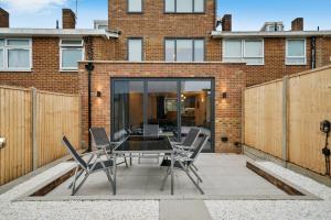 a patio with a table and chairs in front of a building at Luxurious 5 Bed House in London - Pool Table in West Dulwich