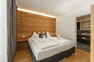 シュラートミンクにあるFree Feel Appartements by Schladming-Appartementsの木製の壁のベッドルーム1室(大型ベッド1台付)