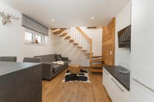 cocina y sala de estar con sofá y escaleras en Free Feel Appartements by Schladming-Appartements, en Schladming
