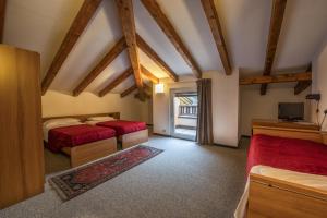 sypialnia z dwoma łóżkami i telewizorem w obiekcie Hotel Drago w mieście Mezzocorona