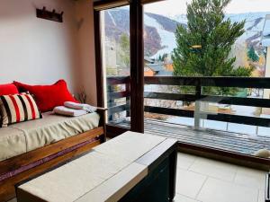 een woonkamer met een bank en een groot raam bij alojamiento en Bariloche CIPRES in Bariloche
