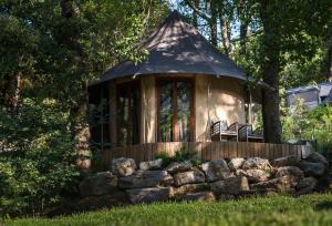 a gazebo with a bench and a pile of rocks at Prehistoric Lodge in Vallon-Pont-dʼArc