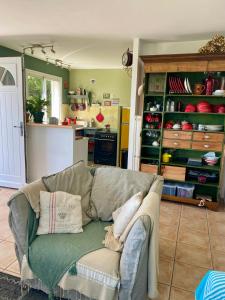 a living room with a couch and a kitchen at un ecrin de verdure face à la mer in Isolaccio-di-Fiumorbo