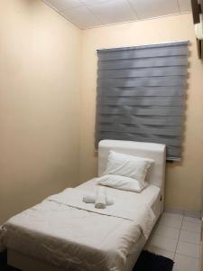 białe łóżko z pluszakiem na górze w obiekcie Azaliza Homestay w mieście Ayer Keroh