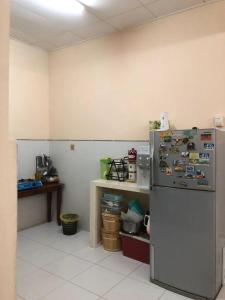 a kitchen with a refrigerator with magnets on it at Azaliza Homestay in Ayer Keroh