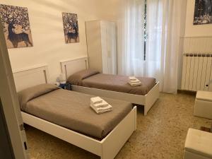 sypialnia z 2 łóżkami i ręcznikami w obiekcie Manubella Appartamento 5 vani con giardino w mieście La Spezia