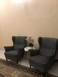 dos sillas y una mesa con un jarrón de flores en Azaliza Homestay en Ayer Keroh