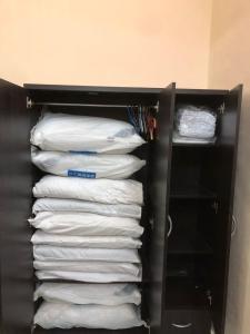 uma pilha de toalhas brancas num armário em Azaliza Homestay em Ayer Keroh