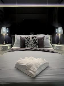 a large white bed with two lamps on two tables at Boutique Hotel Schulz Classic in Neustadt am Rübenberge