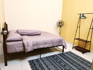 a bedroom with a bed and a rug at Ummi Homestay Bukit Katil Melaka in Kampong Bukit Katil