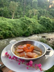 una bandeja llena de carne y hortalizas en una mesa en THANSILA Resort, en Ranong