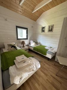 オストロボにあるBalfala domki nad morzemのベッドルーム1室(ベッド2台、ソファ付)