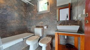 y baño con aseo, lavabo y bañera. en Apart Costa Mediterránea en Villa Gesell