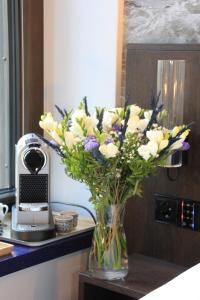 a vase filled with white and purple flowers on a table at Villa Lettonia in Jūrmala