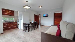 ein Wohnzimmer und eine Küche mit einem Sofa und einem Tisch in der Unterkunft Apart Costa Mediterránea in Villa Gesell