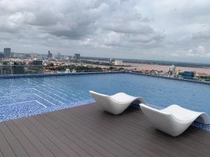 dos sillas blancas sentadas en el techo de un edificio en Cheaper But Biggest Studio Wit Gyms & Pools! Central en Phnom Penh