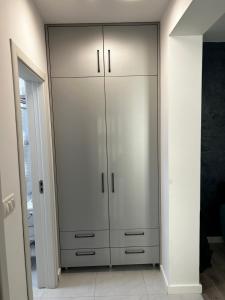 a large closet with white cabinets in a room at Doftana Apartaments in Teşila