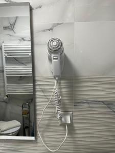 a bathroom with a hair dryer attached to a wall at Doftana Apartaments in Teşila