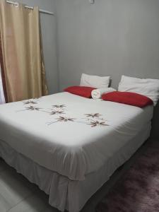 a bedroom with a white bed with flowers on it at Partulaka Rest Inn in Maun