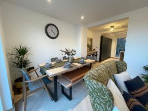 sala de estar con mesa y reloj en la pared en Contemporary Detached Eco House, en Ore