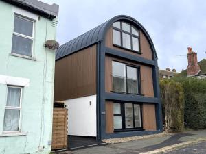 una casa con techo de gambrel con un negro en Contemporary Detached Eco House, en Ore