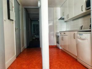 kuchnia z białymi szafkami i pomarańczową podłogą w obiekcie Appartement 3 pièces, 8 pers, Résidence Cassiopée, Flaine Forum, à 50m des pistes et commerces - FR-1-687-87 w mieście Arâches-la-Frasse +7 zdjęć