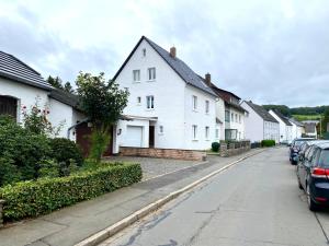 a row of white houses on a residential street at Cozy City Apartment Daun - Ferienwohnung - EIFEL The Natural Home in Daun