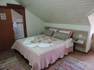 a bedroom with a large bed with a pink blanket at Pousada da Baronesa in Nova Petrópolis