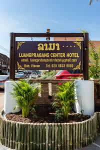 a sign for a luanping center hotel with plants at LuangPrabang Center Hotel in Luang Prabang