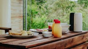 uma mesa com pratos de comida e uma garrafa de sumo de laranja em Dolaço na Chapada- Hospedagem em Alto Paraíso de Goiás