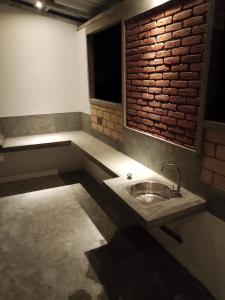 a bathroom with a sink and a brick wall at The Brick Wonder in Habaraduwa