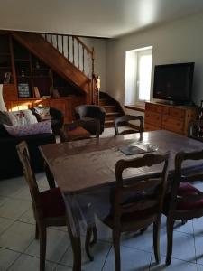 een woonkamer met een houten tafel en stoelen bij Maison de ville au calme in Bonneville